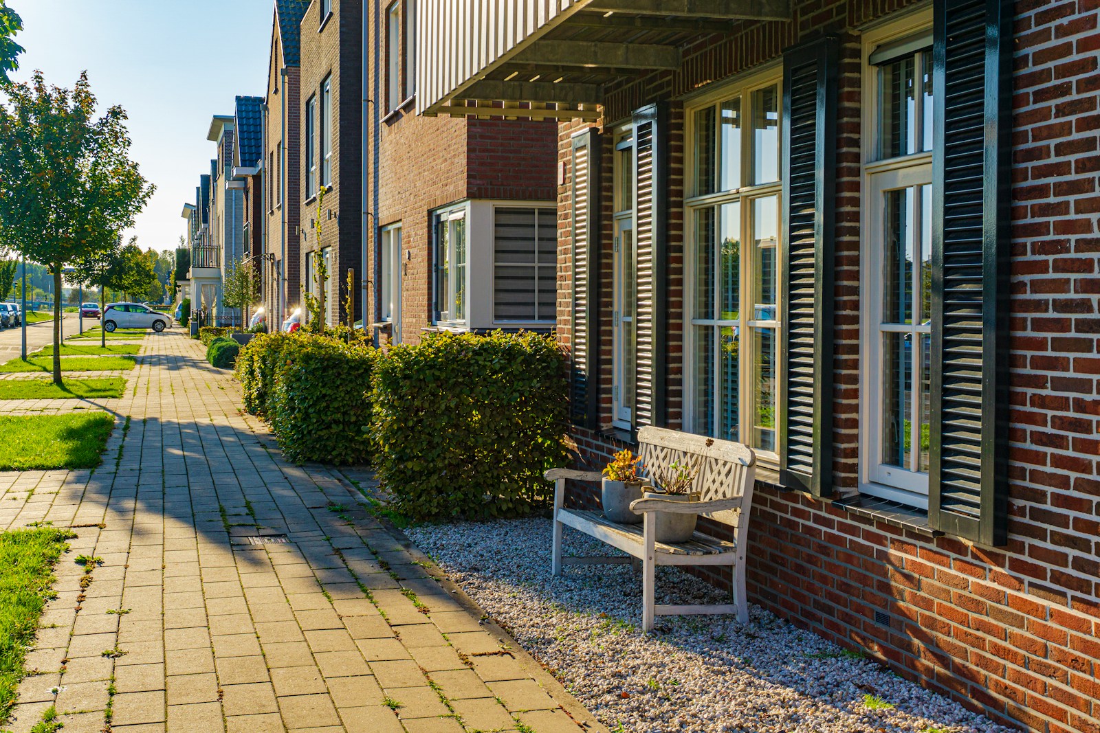 property, brown wooden bench near brown brick building during daytime