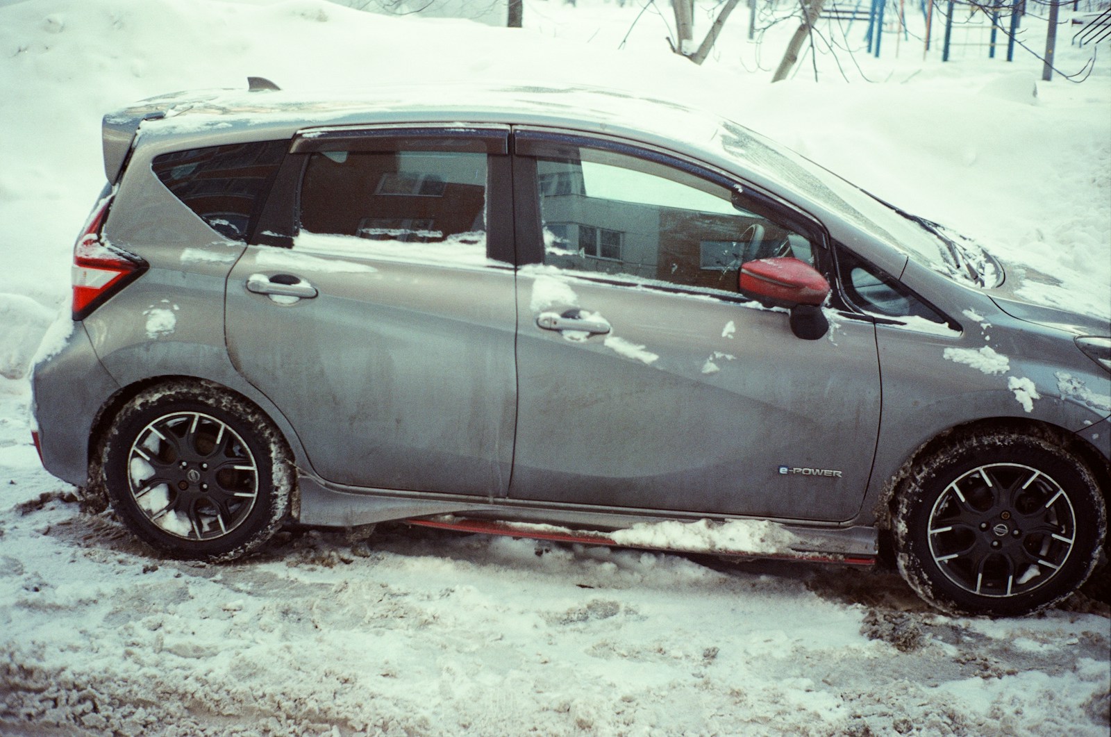 A gray car parked in the snow